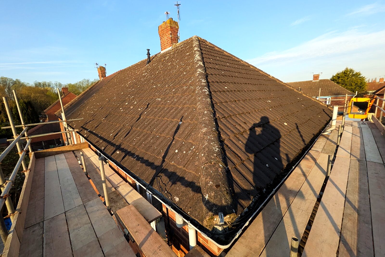 Original hipped tiled roof of a semi-detached house with scaffolding in place