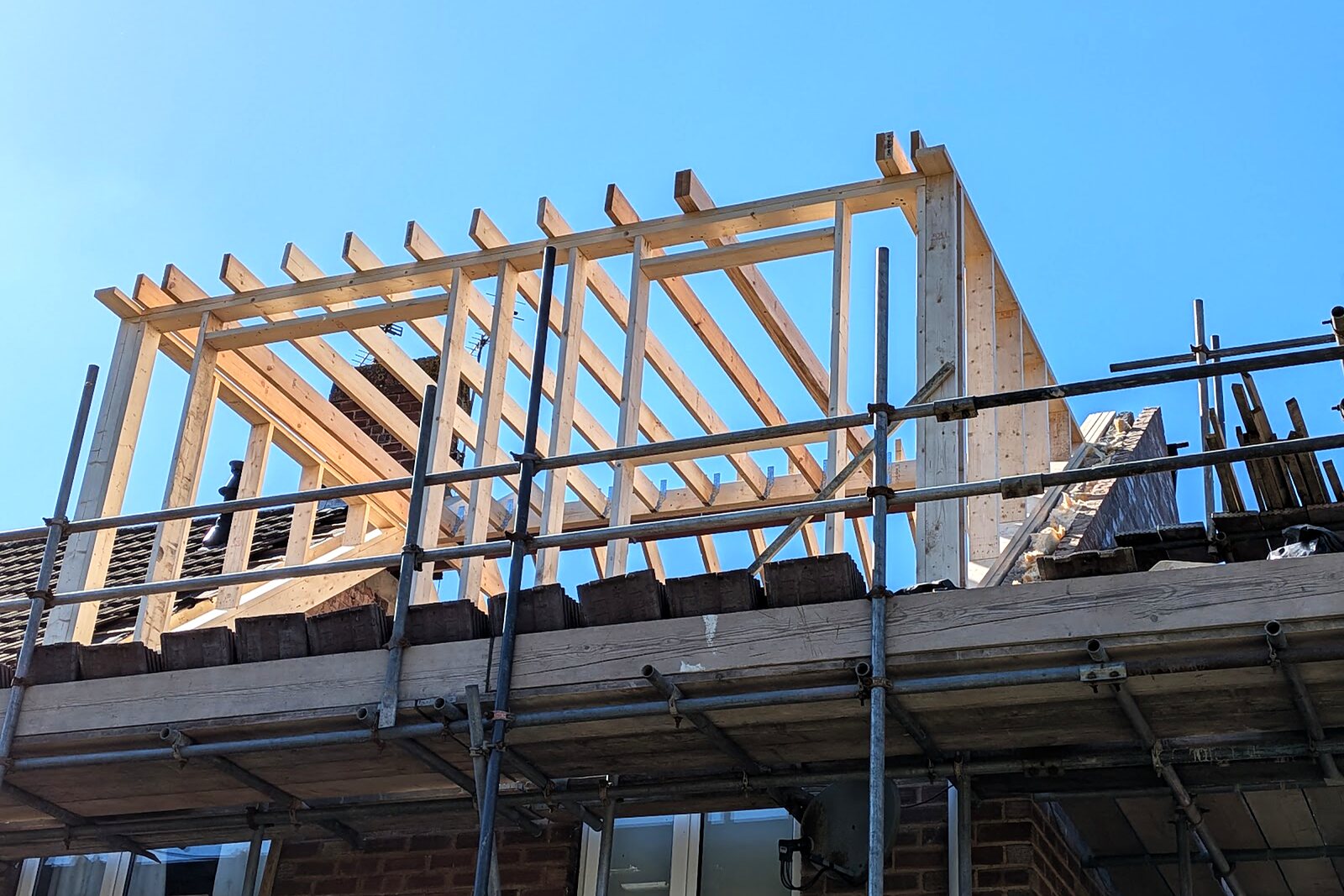 Completed timber roof carcass of the loft dormer against a blue sky