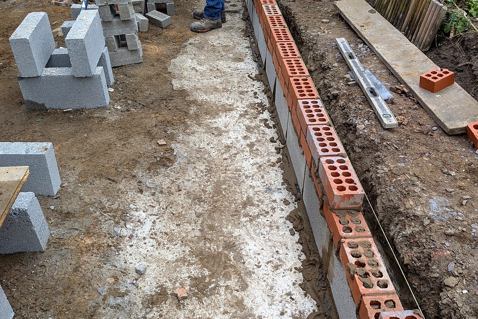 Concrete footings with the first courses of blockwork and brick laid