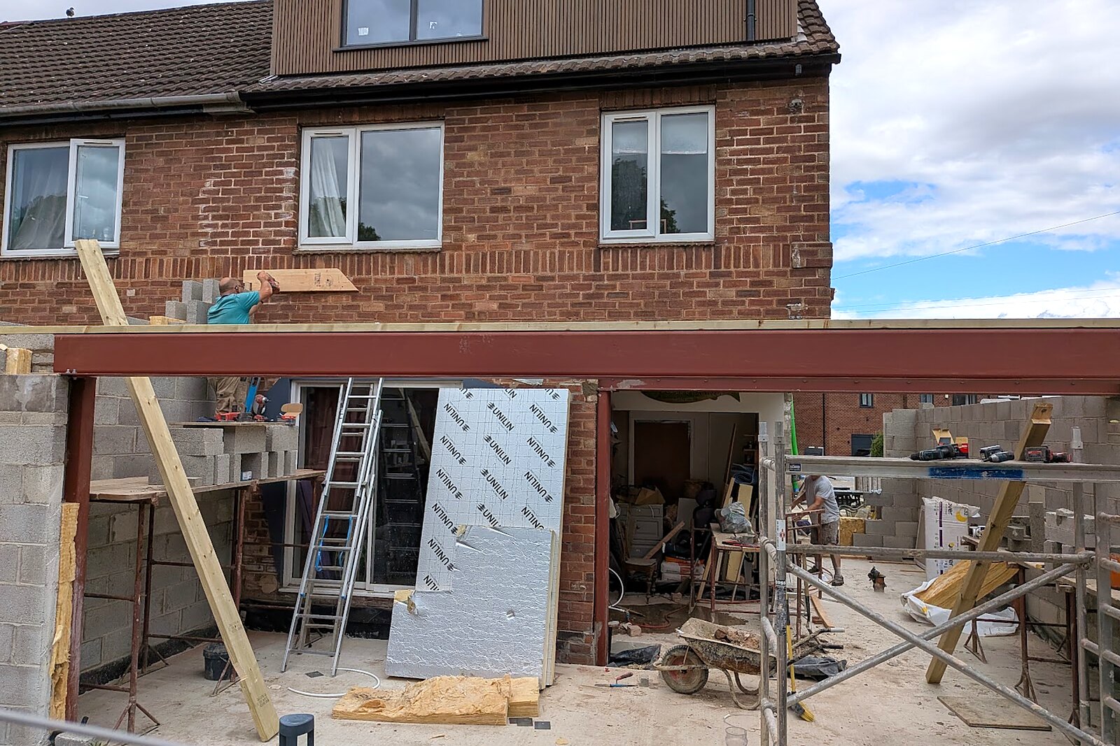 Structural steel beams installed across the rear opening of the house