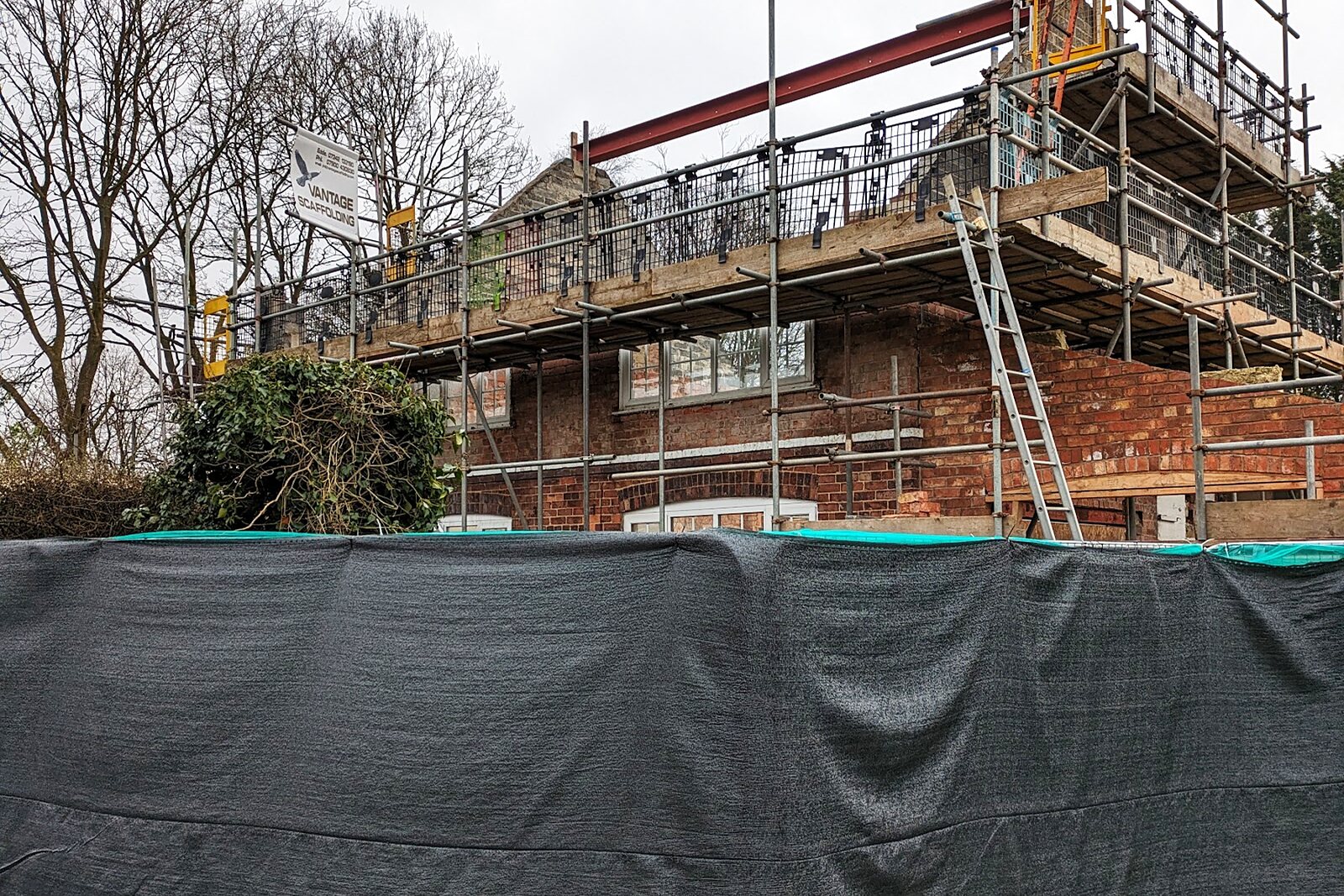 Brick house being rebuilt with full scaffolding around it