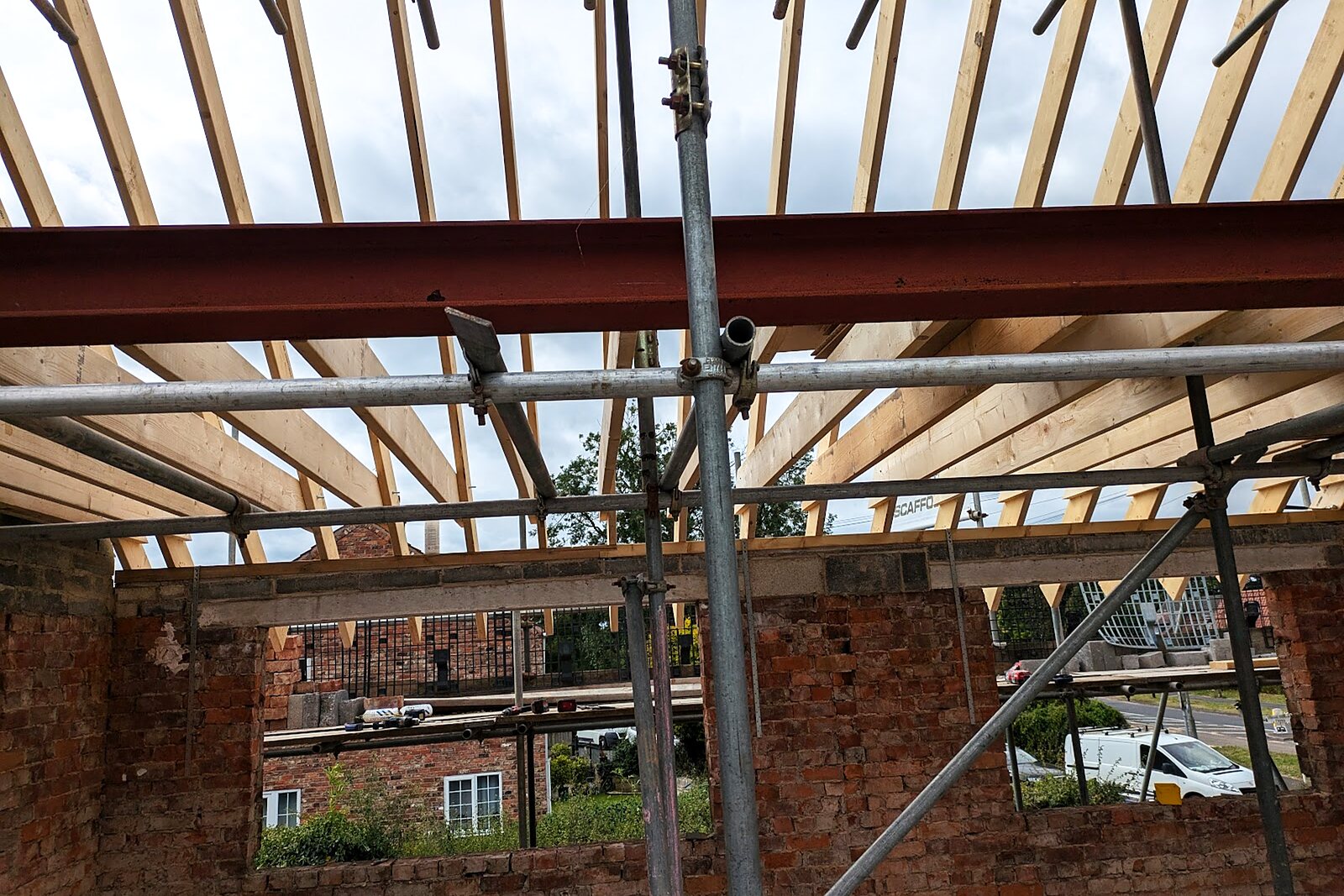 Structural steel beams and new timber roof joists over a brick shell