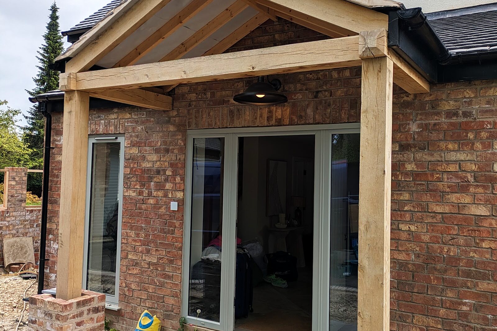 Bespoke green oak porch built onto the brick front elevation of the house